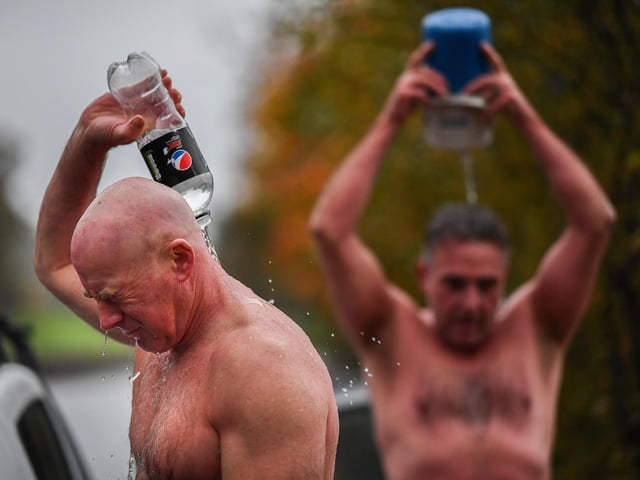 Open water swimming enthusiasts pour warm water over themselves following an early morning swim in Loch Lomond , Trossachs, Scotland. A new study from the UK Dementia Research Institute found that the blood of regular winter swimmers contains a "cold-shock" protein that wasn't found in that of people who did other cold-weather exercise on dry land.