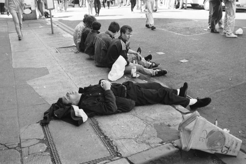 A music fan takes a well-deserved nap on the pavement after the Glasgow’s Big Day concert in June 1990.
