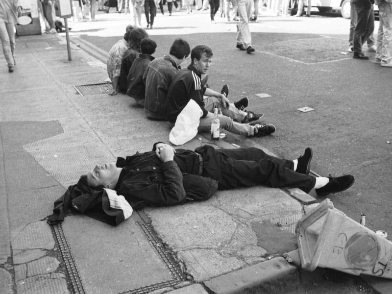 A music fan takes a nap on the pavement after the Glasgow's Big Day concert in June 1990.