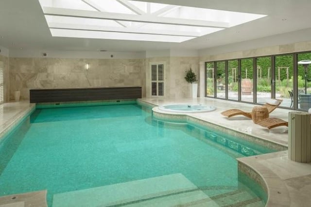 The large swimming pool area includes a jacuzzi, steam room, sauna and changing room, with French doors overlooking the side garden.