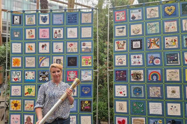 MP for Sheffield Heeley Louise HAigh holds the baton in front of the 'Speak Their Name' quilt, a hand-stitched tribute by loved ones to 192 people who have taken their lives.