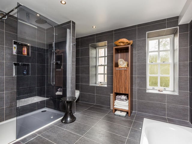A beautifully appointed fully tiled bathroom suite comprising, double walk in shower, sunken bath with hand held shower over, vanity unit with his/hers sinks, W/C and heated towel rail. Ceiling spot lights, feature lighting and underfloor heating.