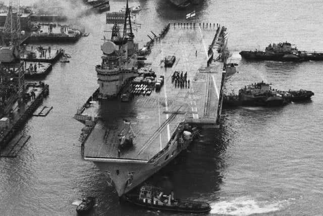 Tugboats move HMS Eagle into her berth after returning to Portsmouth to be paid off and scrapped on 26 January 1972. The Centaur-class light fleet carrier HMS Albion is berthed behind HMS Eagle.
