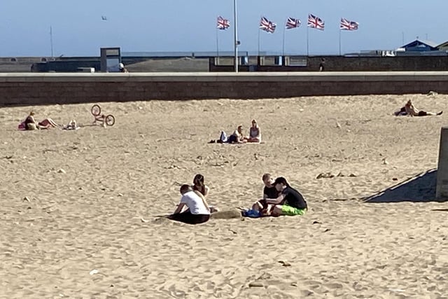 Groups keep their distance as they enjoy the sand.