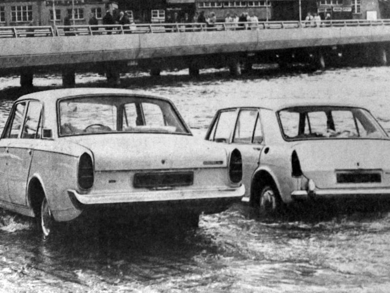 Two cars about to be overcome by the tide on the slipway at the Hard in 1970. The new approach road from the Hard to the Harbour Station can be seen in the background.