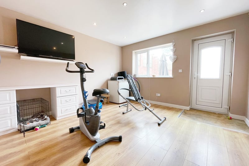 The dining room is currently used as a gym area and has a central heating radiator. It also has a wood style flooring and a rear facing double glazed window.