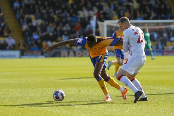 Walsall skipper Peter Clarke tries to slow down Mansfield's Lucas Akins by foul means on Saturday. Photo by Chris Holloway/The Bigger Picture.media