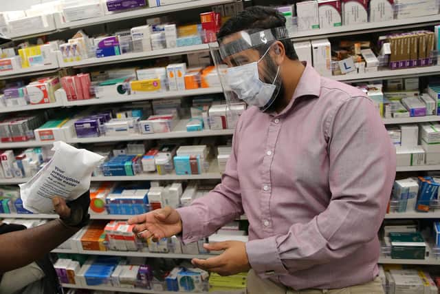 A pharmacist at a Boots Pharmacy, in PPE including a full face mask as a precautionary measure against COVID-19 (Photo by ISABEL INFANTES / AFP) (Photo by ISABEL INFANTES/AFP via Getty Images)