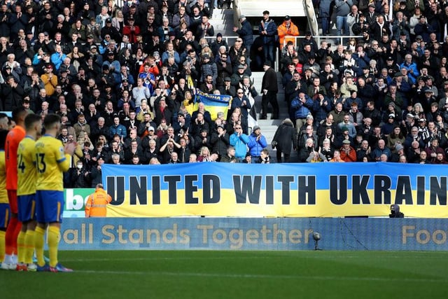 Newcastle supporters in the East Stand hold banners with the Ukrainian flag to indicate peace and sympathy with Ukraine prior to the Brighton and Hove Albion match in March 2022.