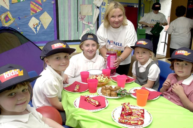 Carrie-Ann  Lodge serves out pop to some of the children who attend The Extra Club at the Darton Primary Schol where they held a party to celebrate the award of a £10,000 grant.
