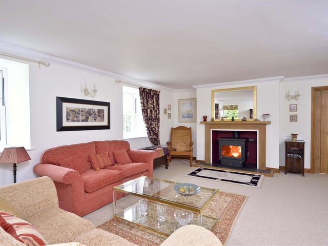 The living room boasts a bespoke fireplace with wood-burning stove