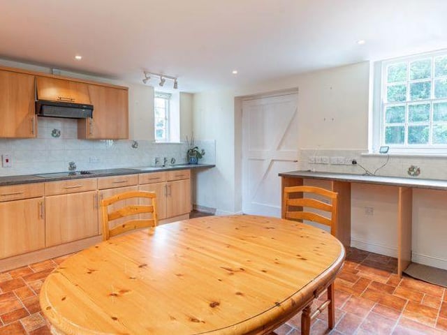 Next to the kitchen is this utility room. It features more units and a sink.