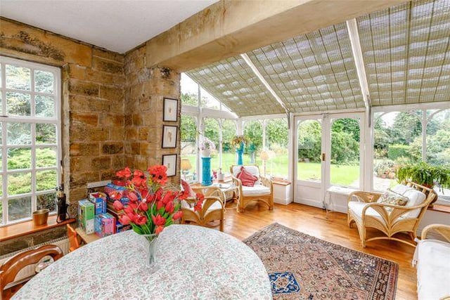 The bright, but cosy family room offers a sunny south facing aspect across the mature gardens