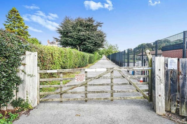 The sweeping, private driveway that leads to the property. It also leads to a large standing area, suitable for the parking of many vehicles.