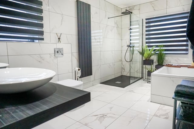 The family bathroom is finished floor-to-ceiling in Carrara marble tiles.