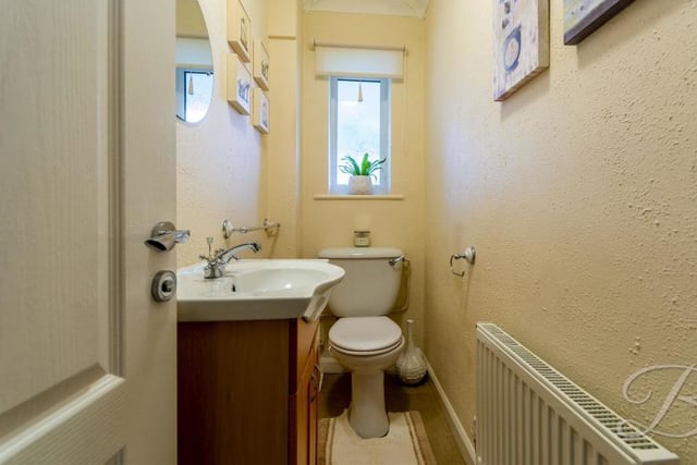 The bungalow's toilet is on the ground floor and comprises a low-flush WC, wash basin with storage, central-heating radiator and opaque window to the front.