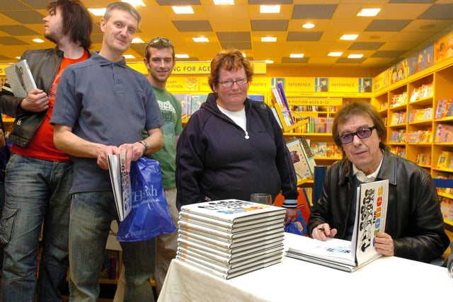 Former Rolling Stone Bill Wyman pictured signing copies of his book at WH Smith's Meadowhall. Picture shows Julie Blackburn of Rotherham getting copies of the book signed for her husband and son who are Rolling Stones fans .