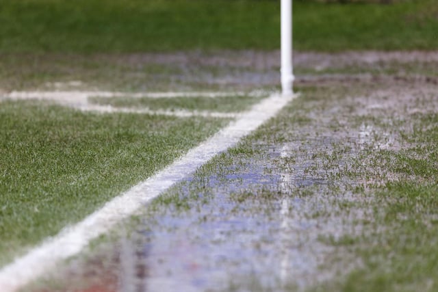 Visible surface water on the pitch and sideline near the corner flag in front of the Main Stand at Gresty Road
