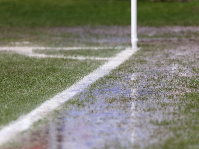 Visible surface water on the pitch and sideline near the corner flag in front of the Main Stand at Gresty Road
