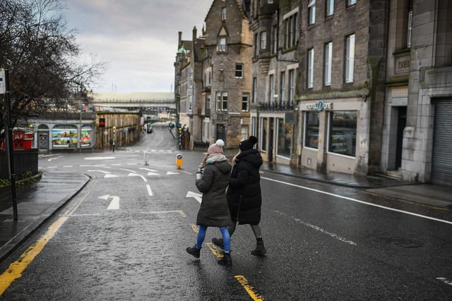 Members of the public walk through a deserted Edinburgh City Centre on January 4, 2021