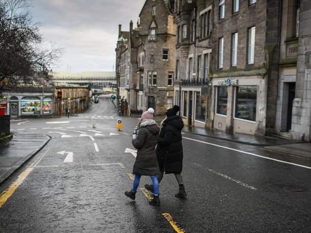 Members of the public walk through a deserted Edinburgh City Centre on January 4, 2021