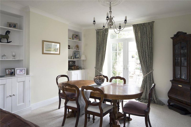 The dining room includes shelving to either side of the chimney breast with fitted cupboards, and French doors opening to the rear garden.