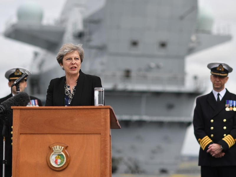 Commodore Jerry Kyd (R), listens as Britain's Prime Minister Theresa May stands on the flight deck and speaks to crew members of HMS Queen Elizabeth after she arrived in Portsmouth for first time. Picture: BEN STANSALL/AFP/Getty Images