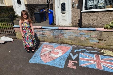 Leila Baxendale, aged seven, poses with her impressive chalk drawings on her street in Intake