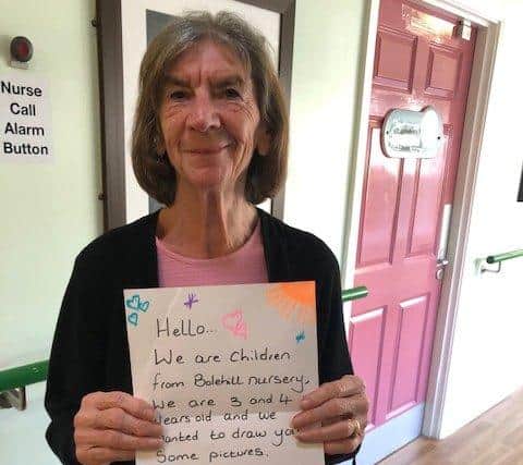 Another patient holding up the letter children sent in.