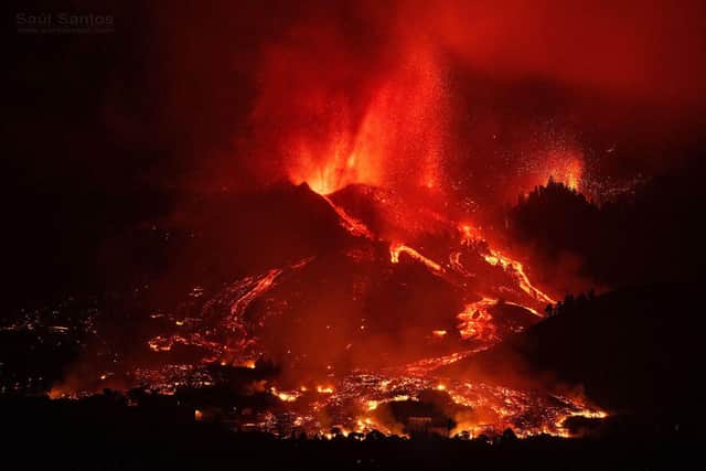 This picture, taken by local photographer Saul Santos in the early days of the La Palma volcano eruption, shows the huge flows of molten lava about to engulf houses at the bottom of the image