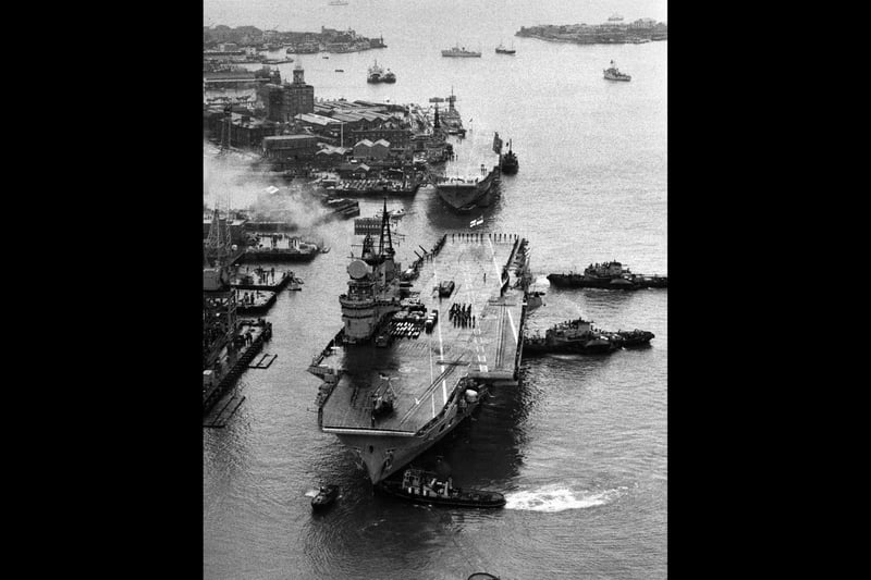 Aerial view the flight deck of the Royal Navy Audacious-class fleet aircraft carrier HMS Eagle as tugboats ease her towards the dockside of Portsmouth harbour to be paid off and scrapped on 26 January 1972 at Portsmouth, United Kingdom. The commando carrier HMS Albion is docked behind HMS Eagle. (Photo by Central Press/Hulton Archive/Getty Images).