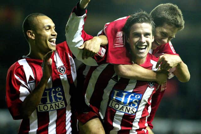 Sheffield United's Andy Gray celebrates his second goal against Leeds United with Danny Webber (L) and Jon Harley (top): Gareth Copley/PA.