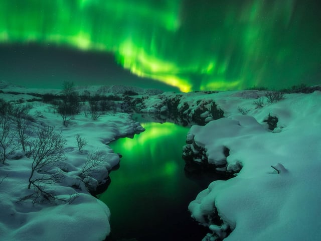 Northern Lights at Thingvellir National Park, Iceland. The day before the chase, there was a blizzard and the roads were full of snow. After waiting 4 hours for the Aurora to show up with no luck, I decided to drive home. My car got stuck in the snow and, when I was waiting for help, the Northern Lights finally showed up and “danced†for about ten minutes. I was lucky to get stuck next to this pond and take this shot with the Aurora reflected on the water.