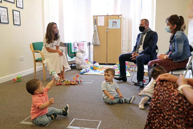 The Duchess of Cambridge, wearing a face mask, talks to the family of Ali Wartty, Sahara Hamawandy and their triplets San, Shan and Laveen, who got supported by Baby Basics