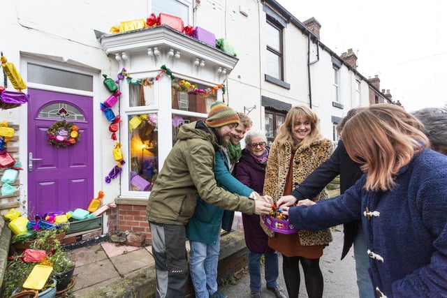 Neighbours on Boyce Street and Bransby Street in Walkley, Sheffield have decorated their homes with Quality Street-themed decorations for Christmas. Kayleigh Thomas, 35, centre, adorned her three-bed terrace with a chocolate-themed display last Christmas and this year 15 more joined in, raising money for S6 Foodbank. They are pictured here enjoying some Quality Streets.