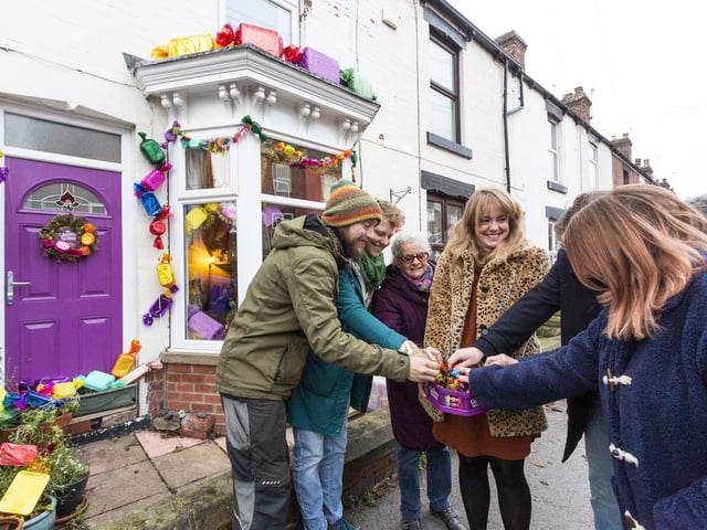 Neighbours on Boyce Street and Bransby Street in Walkley, Sheffield have decorated their homes with Quality Street-themed decorations for Christmas. Kayleigh Thomas, 35, centre, adorned her three-bed terrace with a chocolate-themed display last Christmas and this year 15 more joined in, raising money for S6 Foodbank. They are pictured here enjoying some Quality Streets.