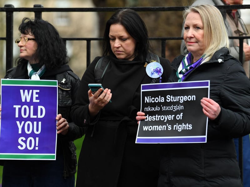 Some demonstrators held placards during a protest as she announced her resignation.