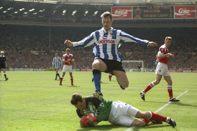 John Sheridan of Sheffield Wednesday leaps over goalkeeper David Seaman of Arsenal during the 1993 FA Cup final at Wembley Stadium.