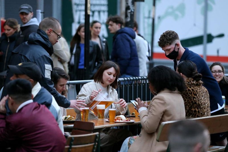 A woman is seen pouring a pint in a pub outdoor seating area on April 16, 2021 in Manchester, England. (Photo by Charlotte Tattersall/Getty Images)