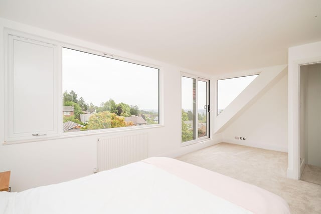 The windows from the master bedroom offer tremendous views across the nearby area. With green treetops and other houses scattering the scenery.