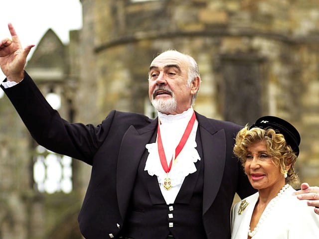 Sir Sean Connery, with wife Micheline, donning full Highland dress and wearing his medal after he was formally knighted by the Queen during a investiture ceremony, at the Palace of Holyroodhouse in Edinburgh.