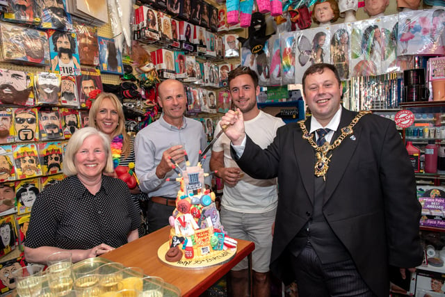 Lord Mayor Cllr Lee Mason prepares to cut the anniversary cake with the owners and staff of the shop
