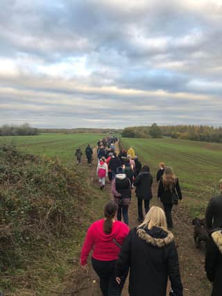 A group of walkers wind their way through the countryside
