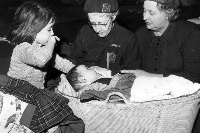 Mrs I Dyson, left, in charge of Cemetery Road Vestry Hall refugee rest centre, with Mrs D Thomas,  WVS deputy county borough organiser, with six-month-old Adrian Wright and six-year-old Susan Wright after the hurricane damage in Sheffield on February 16, 1962