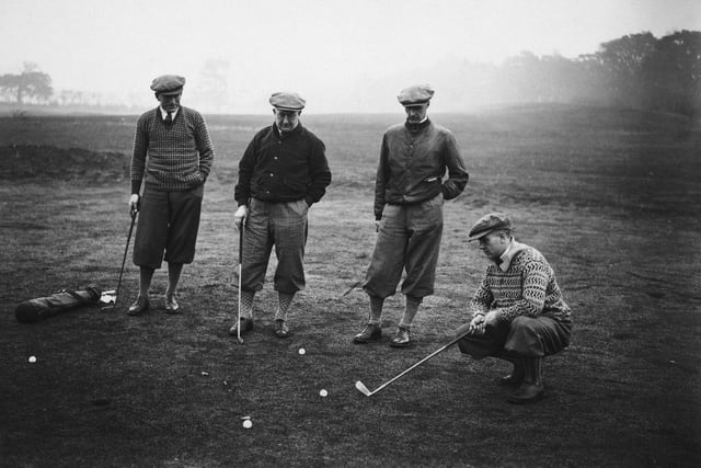 Arsenal footballer Alex James considers his putt during a team training day at a golf course in Hatch End, 14th November 1929. Team mate Tom Parker, manager Herbert Chapman and David Jack look on.