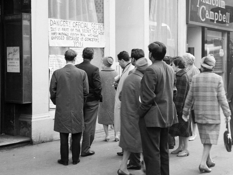 Crowds gather round a shop window on Sauchiehall Street.