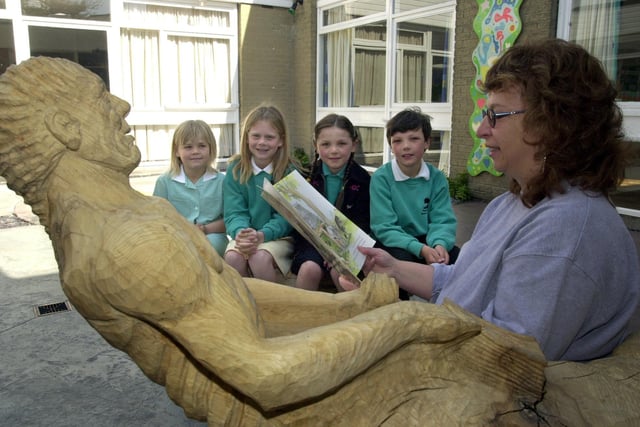 Nook Lane Primary School heateacher Gina Hodges read to pupils in the School's new outdoor story telling quadrangle with wooden scupture by artist Jason Thomson. Left to right, Helena Hodgson, 7, Jenna Hodgson, 9, Margaret Cook, 8 and Robert Cook, aged 9.