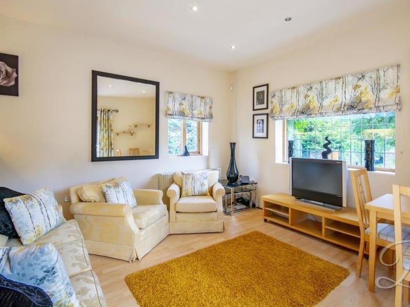 Inside the annexe can be found this living/dining room. It boasts laminated flooring, central-heating radiator and patio doors leading outside.