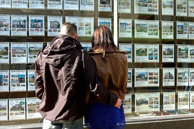 First time buyers looking at property adverts in an estate agent's window. Picture: JPIMedia.