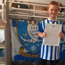 Sheffield Wednesday fan Joshua Lazenby, nine, stands proudly with the letter sent to him by the club for standing up to bullies.